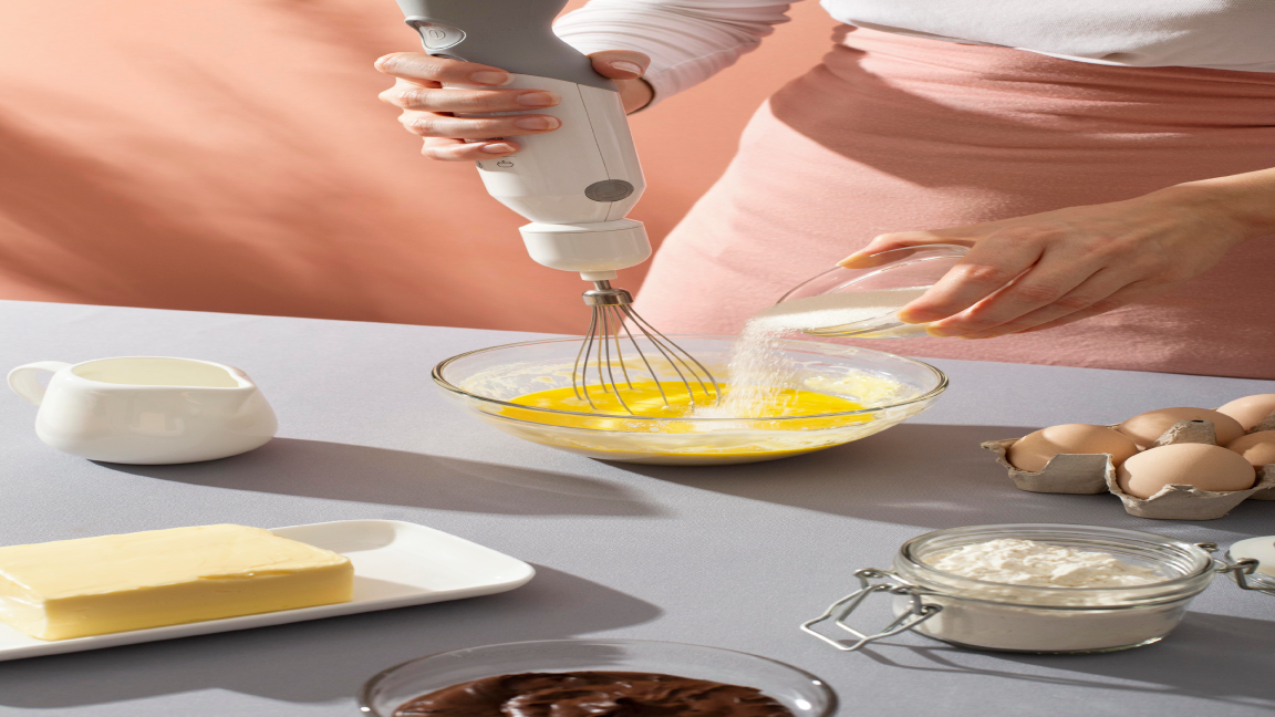 Hand mixer creaming butter and sugar for cake batte