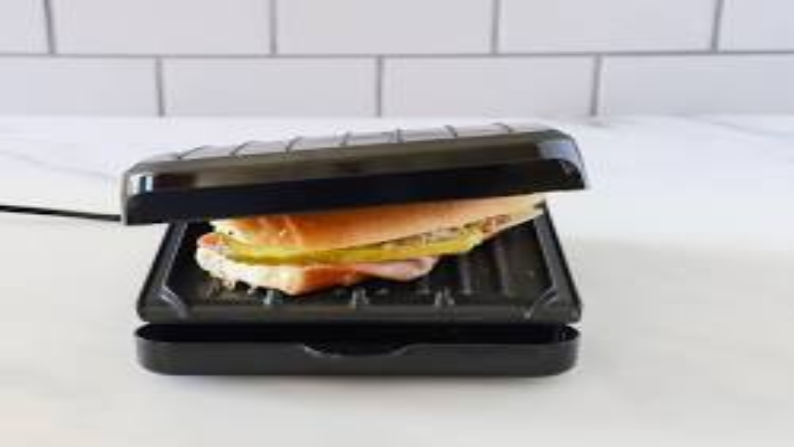 A sandwich being grilled in a black panini press on a kitchen counter